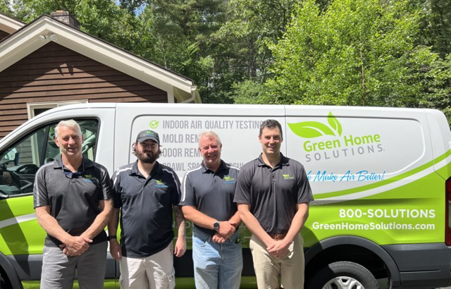 A Green Home Solutions Employee in the Driver Seat of a GHS Van and Another Outside of it Leaning Against the Side Smiling