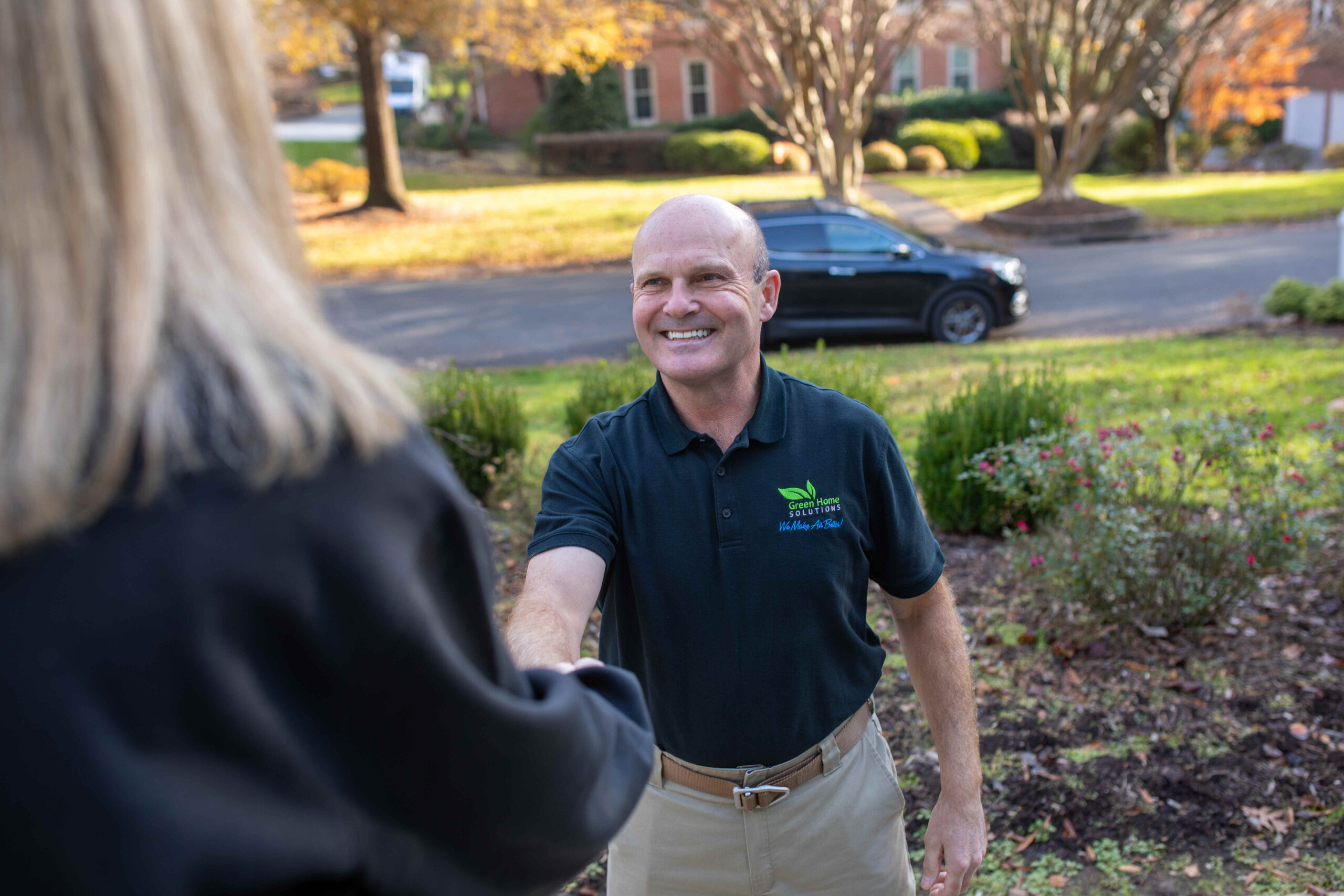 man shaking hands with a woman customer at her door