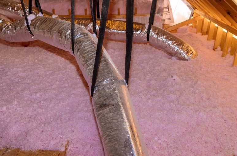 pink blown insulation around duct work in an attic