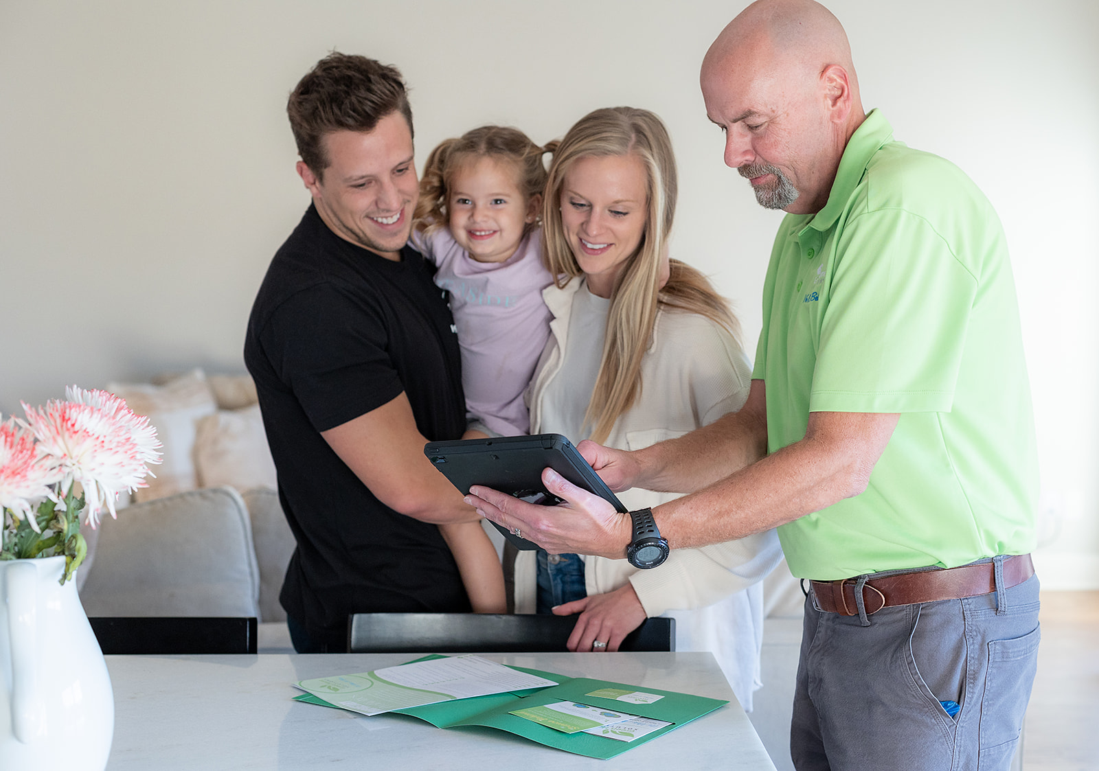 mother, father, and child meeting with a man reviewing documents