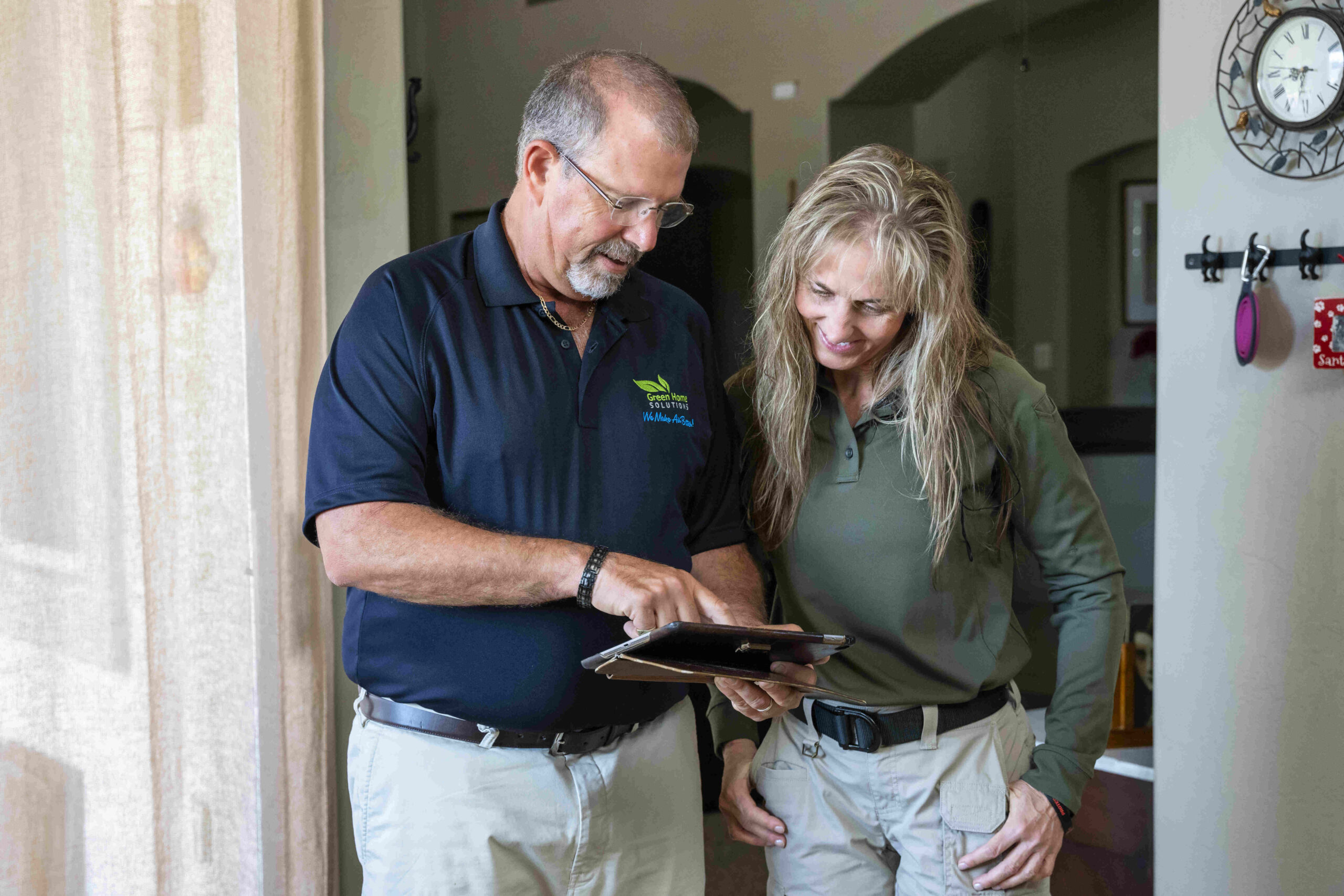 mold technician reviews results with a customer in her kitchen on an ipad