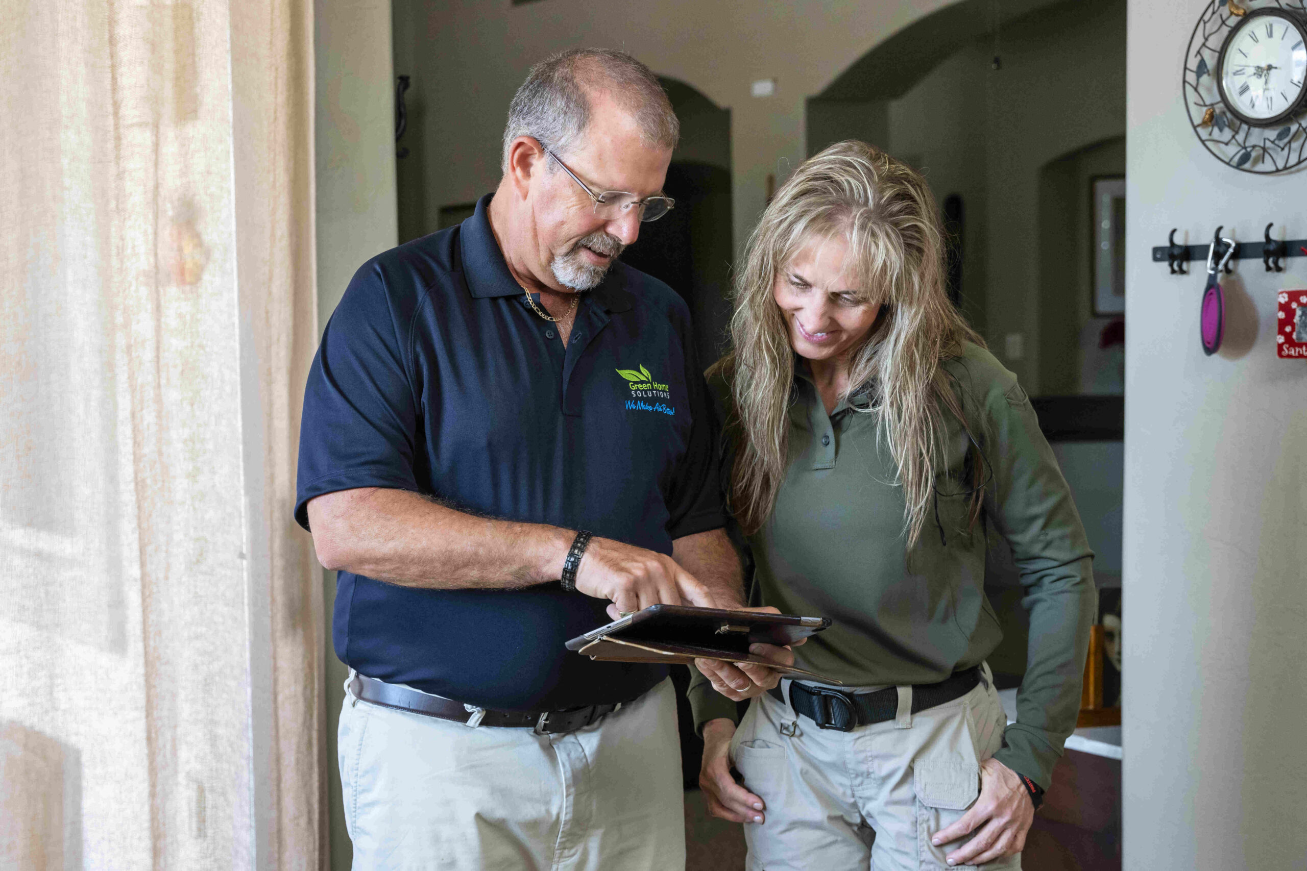 Green Home Solutions Mold Technician in Blacksburg mold technician reviews results with a customer in her kitchen on an ipad
