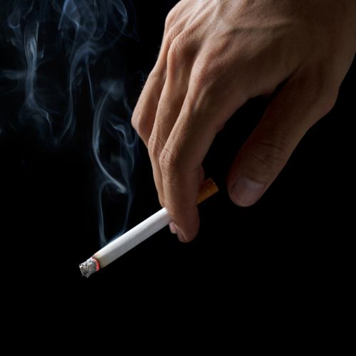 indoor-odor-removal-service hand on black background smoking a cigarette