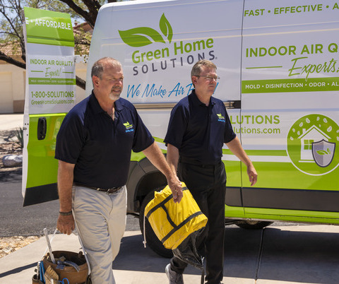 Green Home Solutions - Tucson 18.2 two men in Green Home Solutions uniform walk in front of their van while carrying equipment