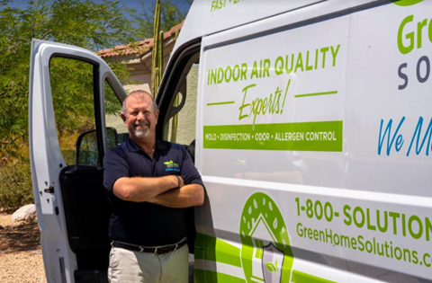 A Man in a Green Home Solutions Polo A Man in a Green Home Solutions Polo Stands Next to an Open Van Door with Green Home Solutions Graphics on the Vehicle