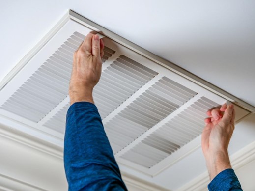 Hands extended to the outside of an air duct.