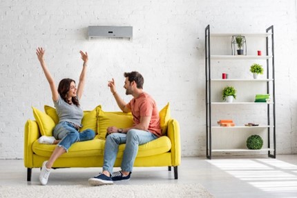 Man and woman sitting on a yellow couch in their mold free home.