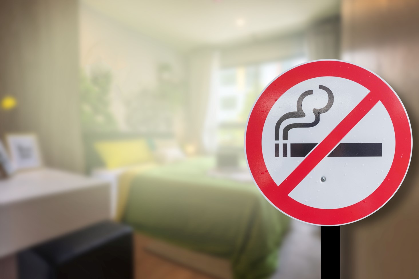 A No Smoking Symbol Overlayed on an Image of a Hazy Bedroom