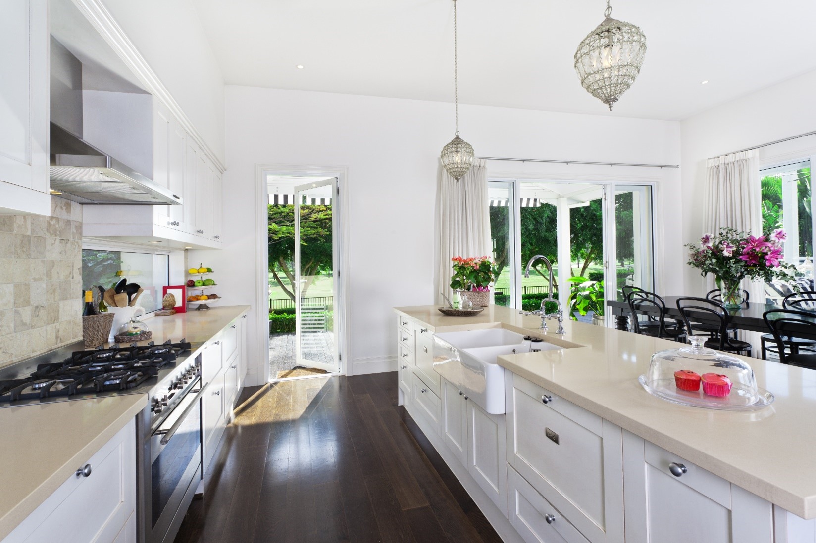 A clean, white kitchen with hardwood floors and fresh flower that is free of mold thanks to mold removal services. 