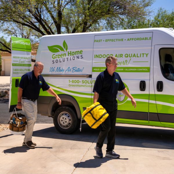 two men working coming out of a white and green van
