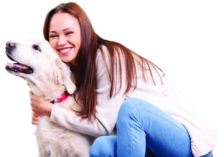 ladyanddog a smiling woman kneeling and hugging dog